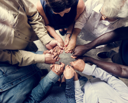 Group of diverse hands holding each other support together teamwork aerial view
