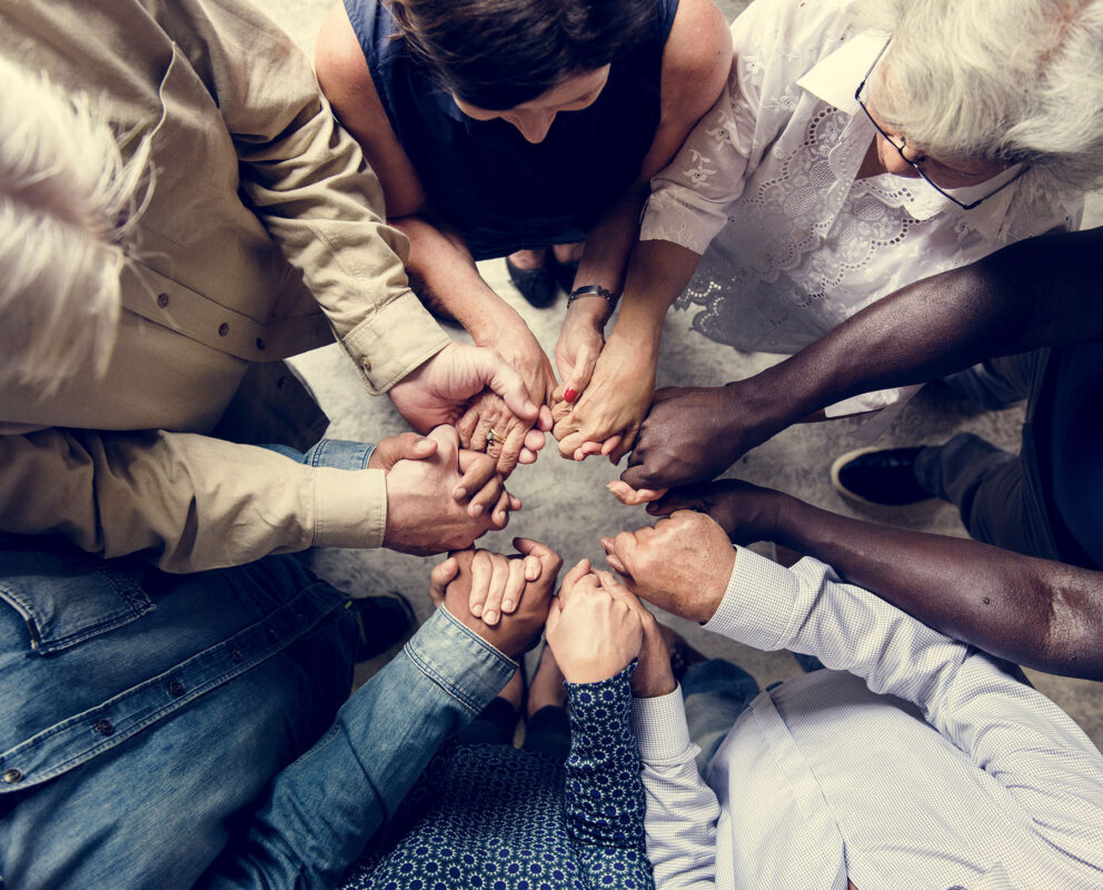 Group of diverse hands holding each other support together teamwork aerial view